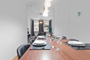 uma sala de jantar com uma mesa de madeira e cadeiras em Flatista Homes - Old Town em Munique