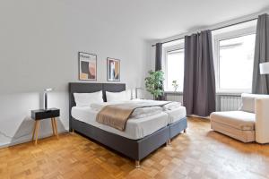 a bedroom with a large bed and a chair at Flatista Homes - Old Town in Munich