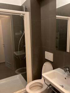 a bathroom with a toilet and a sink and a shower at Twix rooms in Ljubljana