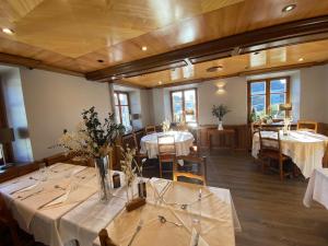 a dining room with tables with white tablecloths at Logis Hôtel Restaurant Au Lion Rouge in Bartenheim