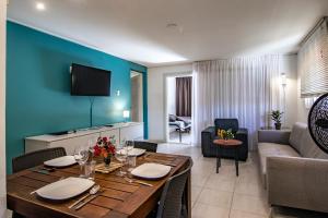 une salle à manger avec une table et un salon dans l'établissement Modern appartement op resort Seru-Coral 4 pers 2 slpk met een groot zwembad, à Willemstad