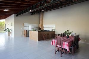 a dining room and kitchen with a table and chairs at Recanto Vale do Sol in Olímpia