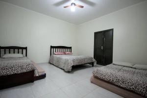 a bedroom with two beds and a ceiling fan at Recanto Vale do Sol in Olímpia +29 photos