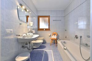 a bathroom with a sink and a toilet and a tub at Obergasserhof in Rodengo