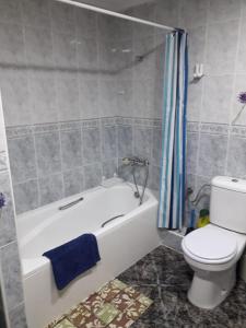 La salle de bains est pourvue de toilettes, d'une baignoire et de toilettes. dans l'établissement Amplio piso en Sagunto, à Sagonte