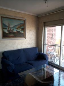 a living room with a blue couch and a glass table at Amplio piso en Sagunto in Sagunto