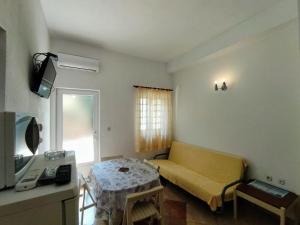 a small living room with a couch and a table at Apartments Lalić - Two bedroom ground floor apartment close to the beach in Tučepi