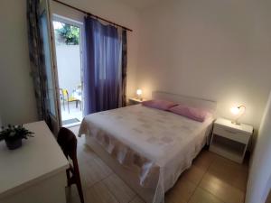 a bedroom with a bed and a table and a window at Apartments Lalić - Two bedroom ground floor apartment close to the beach in Tučepi