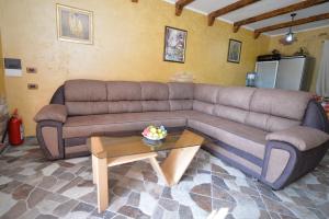 a brown couch in a living room with a table at Vila Andrea in Danilovgrad