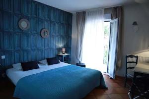 a blue bedroom with a large bed and a window at Hôtel Athéna in Agde +36 photos