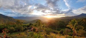 einen Sonnenuntergang über einem Tal mit Bergen und Bäumen in der Unterkunft Finca Naya in Fredonia