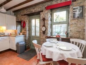 una cucina e una sala da pranzo con tavolo e sedie di 2 Oddfellows Cottages a Hope