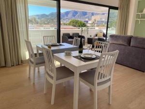 a dining table and chairs in a living room at Holidays2Torremolinos Alamos 3 bedroom & terrace & pool in Torremolinos
