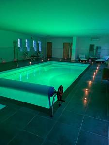 una piscina con iluminación verde en un edificio en Superbe studio privée au calme avec piscine et spa, en Sailly-lès-Lannoy