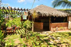 a hut with a table and chairs in a yard at Pousada Paraíso do Caju in Barreirinhas