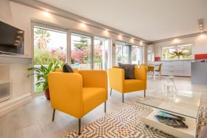 uma sala de estar com cadeiras amarelas e uma mesa de vidro em SilverDeluxe Penthouse - CasaColores, Puerto de la Cruz em Puerto de la Cruz