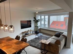 a living room with a couch and a table at Trendy & ruim appartement centum Oostende in Ostend