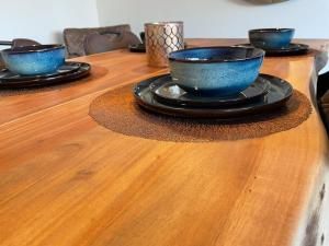 three blue bowls and plates on a wooden table at Trendy & ruim appartement centum Oostende in Ostend
