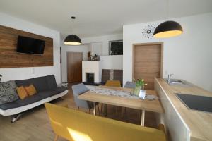 eine Küche und ein Wohnzimmer mit einem Tisch und einem Sofa in der Unterkunft Ferienhaus Viktoria in Abfaltersbach