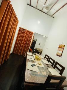 comedor con mesa y cortinas en Uva Escape Holiday Bungalow, en Bandarawela