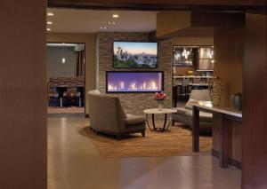 a living room with a fireplace and a tv on a brick wall at Silver Cloud Hotel - Seattle University of Washington District in Seattle