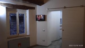 a room with a door and a television on the wall at La casa di Lisa in Suvereto