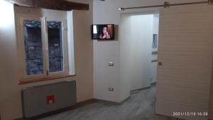 Pokój z telewizorem na ścianie i oknem w obiekcie La casa di Lisa w mieście Suvereto
