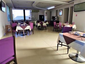 a dining room with tables and purple chairs at Hotel Oasis in Heroica Caborca