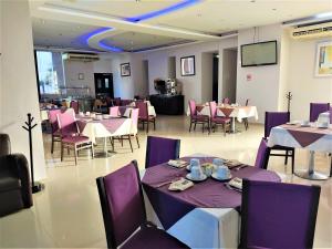 a restaurant with purple tables and chairs and a screen at Hotel Oasis in Heroica Caborca