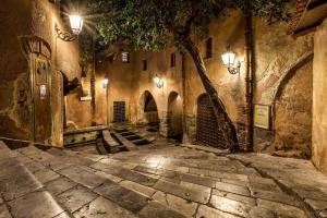 an alley in an old stone building with lights at Kasamare apartments in Cefalù