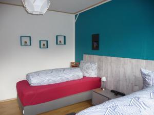 1 dormitorio con cama roja y pared azul en Wohnung "Niedersachsen", en Hohenhameln