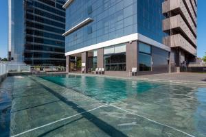 a swimming pool in front of a building at Hilton Garden Inn Praia Brava in Itajaí