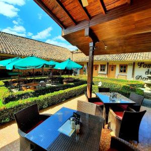 a patio with tables and chairs and umbrellas at Hotel La Posada del Doctor in León