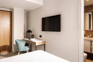 a bedroom with a desk and a tv on a wall at Amery House in Sliema