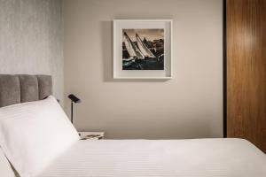 a bedroom with a white bed with a picture on the wall at Amery House in Sliema