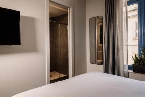 a bedroom with a bed and a glass shower at Amery House in Sliema