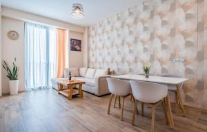 a living room with a couch and a table and chairs at New Gudauri Alpic 406 in Gudauri
