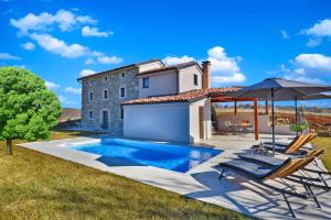 Villa mit einem Pool, 2 Stühlen und einem Sonnenschirm in der Unterkunft Villa Marušići 2140 in Marušići