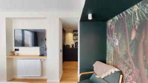 uma sala de estar com uma parede verde e um sofá em Suite lumineuse à Saint-Gilles em Bruxelas