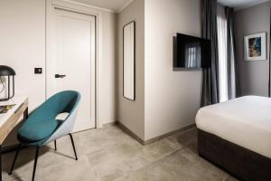 a bedroom with a bed and a desk and a chair at Amery House in Sliema