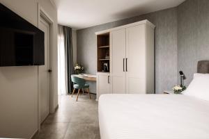 a bedroom with a white bed and a desk at Amery House in Sliema