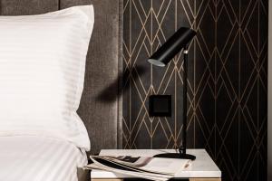 a lamp on a night stand next to a bed at Amery House in Sliema