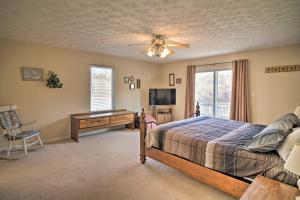 een slaapkamer met een bed, een bureau en een televisie bij Caryville Home with Private Dock and Norris Lake Views in Caryville