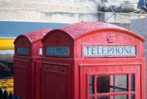two red phone booths sitting next to each other at Amery House in Sliema