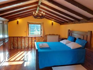 a bedroom with a blue bed and a window at Casa das Vessadas in Celorico de Basto