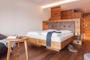 a bedroom with a large bed and a table at Hotel Restaurant Langgenhof in Brunico