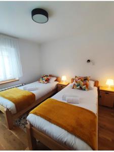 a bedroom with two beds and a window and two lamps at Domek320 in Gronków