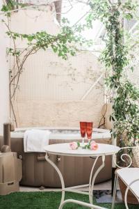 stół z dwoma kieliszkami do wina i kwiatami w obiekcie Amazing House with Jacuzzi and Huge PVT Garden w Atenach
