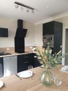 une cuisine avec une table avec un vase de fleurs dessus dans l'établissement LA Maison D'AGEN, à Boé