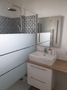 une salle de bains avec un lavabo et un miroir dans l'établissement LA Maison D'AGEN, à Boé 19 autres photos